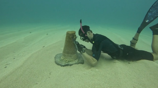 Matt, Lu‘uLive founder, locking the GoPro into a concrete seafloor mount.
